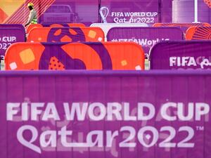 A worker walks past FIFA World Cup banners outside the Khalifa Stadium in Doha on November 6, 2022, ahead of the Qatar 2022 FIFA World Cup football tournament. (Photo by Kirill KUDRYAVTSEV / AFP)