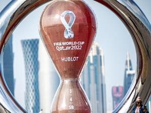 A woman takes pictures in front of the World Cup countdown clock in Doha on November 17, 2022, ahead of the Qatar 2022 World Cup football tournament. (Photo by Philip FONG / AFP)