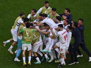 Iran's players celebrate after scoring the opening goal during the Qatar 2022 World Cup Group B football match between Wales and Iran at the Ahmad Bin Ali Stadium in Al-Rayyan, west of Doha on November 25, 2022. (Photo by Antonin THUILLIER / AFP)