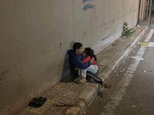 فتى لبناني يحتضن أخته الصغيرة بعد ليلة شديدة البرودة في شارع بالعاصمة بيروت.