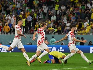 Croatia players celebrate past Brazil's defender #04 Marquinhos (C) after they won on penalty shoot-out the Qatar 2022 World Cup quarter-final football match between Croatia and Brazil at Education City Stadium in Al-Rayyan, west of Doha, on December 9, 2022. (Photo by NELSON ALMEIDA / AFP)