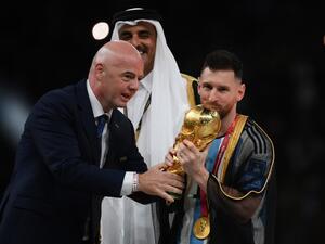 Argentina's forward #10 Lionel Messi kisses the World Cup trophy beside FIFA President Gianni Infantino (L) as Qatar's Emir Sheikh Tamim bin Hamad al-Thani watches after the Qatar 2022 World Cup final football match between Argentina and France at Lusail Stadium in Lusail, north of Doha on December 18, 2022. (Photo by FRANCK FIFE / AFP) Lionel Messi