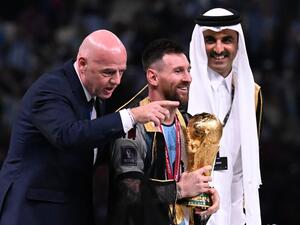 Argentina's captain and forward #10 Lionel Messi holds the FIFA World Cup Trophy next to FIFA President Gianni Infantino and Qatar's Emir Sheikh Tamim bin Hamad al-Thani (R) during the trophy ceremony after Argentina won the Qatar 2022 World Cup final football match between Argentina and France at Lusail Stadium in Lusail, north of Doha on December 18, 2022. (Photo by Kirill KUDRYAVTSEV / AFP)