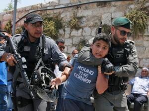 An Israeli soldier arresting a Palestinian youth 