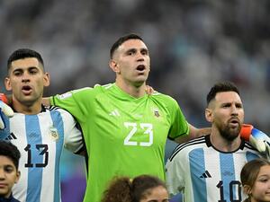 Argentina's defender #13 Cristian Romero, Argentina's goalkeeper #23 Emiliano Martinez and Argentina's forward #10 Lionel Messi sing the national anthem ahead of the Qatar 2022 World Cup football semi-final match between Argentina and Croatia at Lusail Stadium in Lusail, north of Doha on December 13, 2022. (Photo by JUAN MABROMATA / AFP)