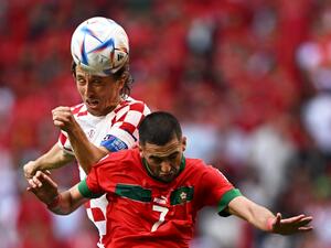 Croatia's midfielder #10 Luka Modric and Morocco's midfielder #07 Hakim Ziyech jump for a header during the Qatar 2022 World Cup Group F football match between Morocco and Croatia at the Al-Bayt Stadium in Al Khor, north of Doha on November 23, 2022. (Photo by MANAN VATSYAYANA / AFP)