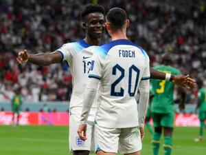 England's forward #17 Bukayo Saka celebrates with England's forward #20 Phil Foden after scoring his team's third goal during the Qatar 2022 World Cup round of 16 football match between England and Senegal at the Al-Bayt Stadium in Al Khor, north of Doha on December 4, 2022. (Photo by Paul ELLIS / AFP)