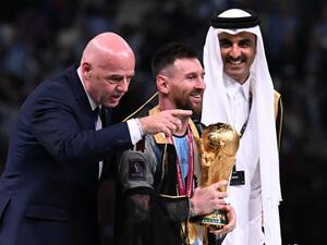 Argentina's captain and forward #10 Lionel Messi holds the FIFA World Cup Trophy next to FIFA President Gianni Infantino and Qatar's Emir Sheikh Tamim bin Hamad al-Thani (R) during the trophy ceremony after Argentina won the Qatar 2022 World Cup final football match between Argentina and France at Lusail Stadium in Lusail, north of Doha on December 18, 2022. (Photo by Kirill KUDRYAVTSEV / AFP)
