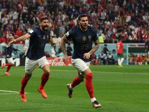 France's defender #22 Theo Hernandez celebrates, with France's forward #09 Olivier Giroud running behind, after scoring his team's first goal during the Qatar 2022 World Cup semi-final football match between France and Morocco at the Al-Bayt Stadium in Al Khor, north of Doha on December 14, 2022. (Photo by Adrian DENNIS / AFP)