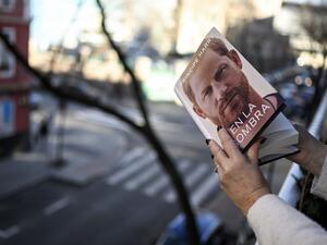 A woman leafs through the "En la sombra" (In the shadow) Spanish version of the book "Spare" an autbiography by Britain's Prince Harry after buying it in Madrid on January 5, 2023. (Photo by OSCAR DEL POZO / AFP) Prince Harry