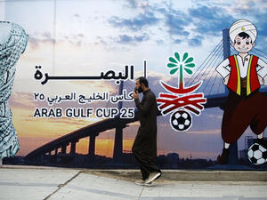 A man walks past a poster announcing the 25th Arabian Gulf Cup football championship, in the Al-Ashar district of Iraq's southern city of Basra, on January 5, 2023. (Photo by AHMAD AL-RUBAYE / AFP) Arabian Gulf Cup