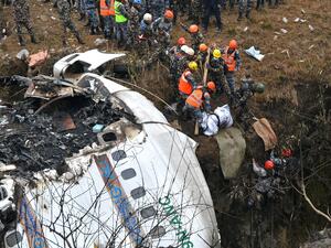 Graphic content / Rescuers pull the body of a victim who died in a Yeti Airlines plane crash in Pokhara on January 16, 2023. (Photo by PRAKASH MATHEMA / AFP) plane crash