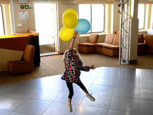 A Ukrainian girl plays with balloons with the colours of her country's flag aboard the Corsica Linea ferry "Mediterranee" in Marseille, southern France, on April 26, 2022. (Photo by Nicolas TUCAT / AFP) Ukrainian refugees
