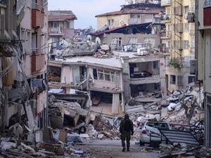 A Turkish soldier walks among destroyed buildings in Hatay, on February 12, 2023, after a 7.8-magnitude earthquake struck the country's south-east. (Photo by Yasin AKGUL / AFP) earthquake