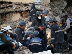 Rescuers take a break amid the rubble of collapsed buildings as they search for survivors and victims, after a 7.8 magnitude earthquake struck the border region of Turkey and Syria earlier in the week, in Kahramanmaras on February 12, 2023. (Photo by OZAN KOSE / AFP) rescue team