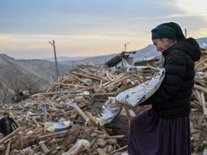 امرأة تبكي وهي تجمع متعلقاتها الشخصية فوق أنقاض منزلها المنهار عقب زلزال تركيا