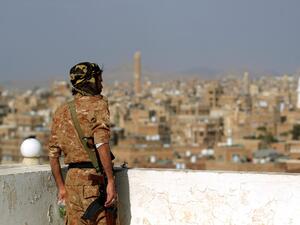 A member of Huthi-affiliated security forces looks at UNESCO-listed buildings in the old city of the rebel-held Yemeni capital Sanaa, on February 24, 2023. (Photo by Mohammed HUWAIS / AFP) Yemen