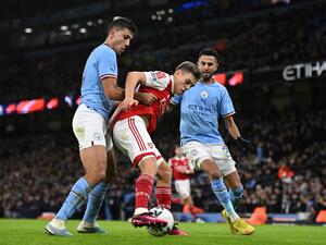 Arsenal's Belgian midfielder Leandro Trossard (C) challenges Manchester City's Spanish midfielder Rodri (L) and Manchester City's Algerian midfielder Riyad Mahrez (R) during the English FA Cup fourth round football match between Manchester City and Arsenal at the Etihad Stadium in Manchester, northwest England, on January 27, 2023. (Photo by Oli SCARFF / AFP)