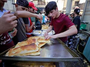 Iraqis muslims buy Geymar with Kahi (Iraqi clotted cream) in Baghdad's Sadriya neighbourhood on the Eid al-Fitr holiday marking the end of the holy month of Ramadan, on May 2, 2022. (Photo by AHMAD AL-RUBAYE / AFP) Ramadan