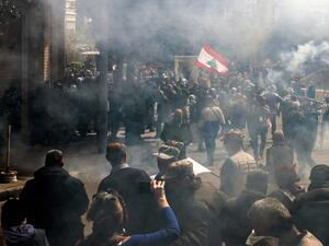 Tear gas fumes fill the air as retired Lebanese army and security forces veterans attempt to break into the government palace premises in the centre of Beirut on March 22, 2023 during a demonstration demanding inflation-adjustments to their pensions. (Photo by JOSEPH EID / AFP) security forces