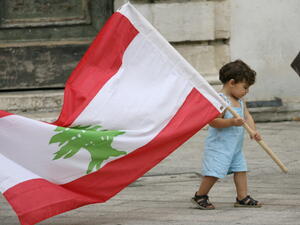 طفل صغير يحمل علم لبنان