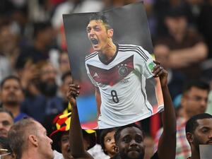 A supporter holds up a poster of German football player Mesut Ozil during the Qatar 2022 World Cup Group E football match between Costa Rica and Germany at the Al-Bayt Stadium in Al Khor, north of Doha on December 1, 2022. (Photo by Glyn KIRK / AFP)