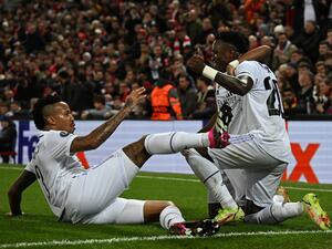Real Madrid's Brazilian forward Vinicius Junior (R) celebrates scoring the team's second goal with Real Madrid's Brazilian forward Rodrygo (C) and Real Madrid's Brazilian defender Eder Militao during the UEFA Champions League last 16 first leg football match between Liverpool and Real Madrid at Anfield in Liverpool, north west England on February 21, 2023. (Photo by Paul ELLIS / AFP)