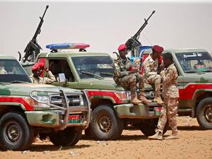 Members of Sudanese paramilitary Rapid Support Forces (RSF) celebrate as they lead dozens of African nationals, caught as they tried to cross into Libya illegally, in front of the media a desert area called Gouz Abudloaa. AFP / ASHRAF SHAZLY sudan army