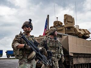 U.S. army soldiers stand near an armoured military vehicle on the outskirts of Rumaylan in Syria's northeastern Hasakeh province, bordering Turkey, on March 27, 2023. (Photo by Delil souleiman / AFP) ISIS leader