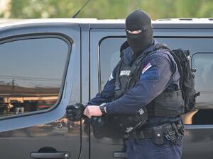 A masked policeman secures an area in the village of Dubona near the town of Mladenovac, about 60 kilometers (37 miles) south of Serbia's capital Belgrade, on May 5, 2023. (Photo by ANDREJ ISAKOVIC / AFP) Serbia mass shooting kills 8