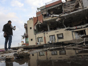 A man takes pictures of a damaged building after an Israeli airstrike in Gaza City, Palestininan Territories on May 9, 2023. (Photo by MOHAMMED ABED / AFP) Gaza