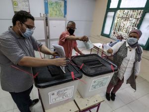 Voters, mask-clad due to the COVID-19 coronavirus pandemic, cast their ballots at a polling station in the Egyptian capital's twin city of Giza. (AFP / Mohamed el-Shahed) Ballots