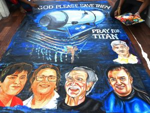 Art school students give final touches to a painting depicting five people aboard a submersible named Titan, that went missing near the wreck of the Titanic, in Mumbai on June 22, 2023. (Photo by INDRANIL MUKHERJEE / AFP) Titanic submersible