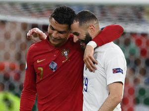 Portugal's forward Cristiano Ronaldo and France's forward Karim Benzema walk together off the pitch in half-time of the UEFA EURO 2020 Group F football match between Portugal and France at Puskas Arena in Budapest on June 23, 2021. / AFP / POOL / FRANCK FIFE
