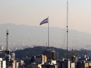 A general view shows the Iranian capital Tehran on January 7, 2023, with the Iranian flag fluttering in the wind. (Photo by ATTA KENARE / AFP) tehran