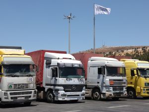 A convoy of trucks carrying humanitarian aid is seen parked after crossing the Syrian Bab al-Hawa border crossing with Turkey. (Photo by OMAR HAJ KADOUR / AFP) Aid concoys