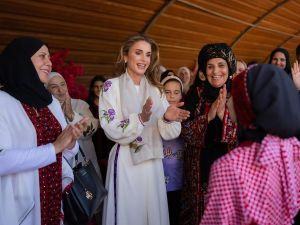 الملكة رانيا ترتدي زيا تراثيا أبيض اللون وسط مجموعة من النساء 