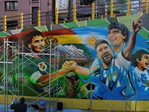 Local artists paint a mural depicting Argentine players Lionel Messi (3-R), Mario Kempes (R) and late Diego Maradona and Bolivia's Marco Antonio Etcheverry, Carlos Borja and Ramiro Castillo, in La Paz on September 10, 2023, ahead of the 2026 FIFA World Cup South American qualifier football match between Bolivia and Argentina on September 12. (Photo by JORGE BERNAL / AFP)