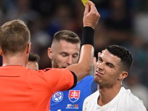 Portugal's forward #07 Cristiano Ronaldo (R) is shown a yellow card by Swedish referee Glenn Nyberg reacts during during the UEFA EURO 2024 qualifying football match between Slovakia and Portugal in Bratislava on September 8, 2023. (Photo by VLADIMIR SIMICEK / AFP)