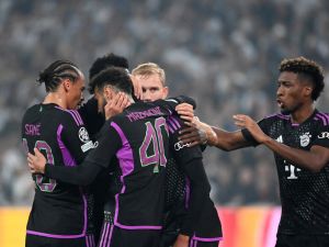 Bayern Munich's players celebrate Bayern Munich's German midfielder #42 Jamal Musiala (hidden) after he scored the 1-1 goal during the UEFA Champions League Group A football match between FC Copenhagen and FC Bayern Munich in Copenhagen, Denmark on October 3, 2023. (Photo by Sergei GAPON / AFP)
