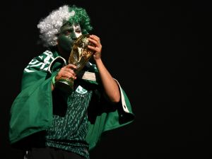 A Saudi Arabia fan kisses a replica of the FIFA World Cup trophy ahead of the Qatar 2022 World Cup Group C football match between Poland and Saudi Arabia at the Education City Stadium in Al-Rayyan, west of Doha on November 26, 2022. (Photo by Glyn KIRK / AFP)