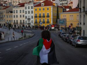 A woman wearing a Palestinian flag takes part in a demonstration to demand a cease-fire in the Palestinian territories, in Lisbon on November 18, 2023. (Photo by PATRICIA DE MELO MOREIRA / AFP) Palestinian flag