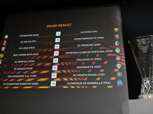 The results are displayed on a screen next to the UEFA Europa League cup at the end of the UEFA Europa League knockout stage play-off draw at the House of European Football in Nyon on December 18, 2023. (Photo by Fabrice COFFRINI / AFP)