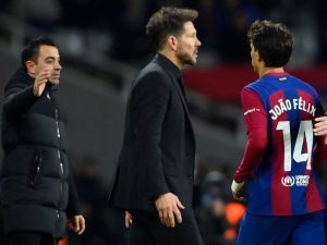 Barcelona's Portuguese forward #14 Joao Felix walks past Atletico Madrid's Argentinian coach Diego Simeone as Barcelona's Spanish coach Xavi (L) waits for shaking hands with him after being substituted during the Spanish league football match between FC Barcelona and Club Atletico de Madrid at the Estadi Olimpic Lluis Companys in Barcelona on December 3, 2023. (Photo by Pau BARRENA / AFP)