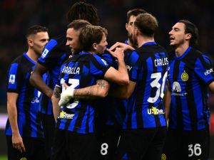 Inter Milan's Italian midfielder #23 Nicolo Barella celebrates with teammates after scoring his team's second goal during the Italian Serie A football match between Inter Milan and Lecce at the “San Siro Stadium” in Milan on December 23, 2023. (Photo by MARCO BERTORELLO / AFP)