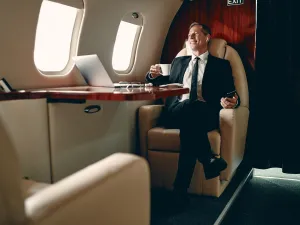 Senior businessman in suit flying in private jet