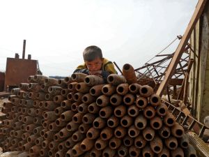 طفل سوري يجلس فوق أسلحة استعملها النظام السوري في ضرب أهداف مدنية. أرشيف. وكالة الصحافة الفرنسية.