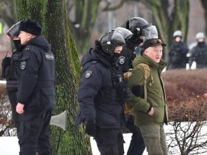 Police officers detain a man as people come to the monument to the victims of political repressions to lay flowers for late Russian opposition leader Alexei Navalny in Saint Petersburg on February 17, 2024, one day after the death of Navalny in an Arctic prison. (Photo by Olga MALTSEVA / AFP)