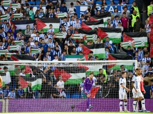 Supporters hold Palestinian flags during the Spanish league football match between Real Sociedad and RCD Mallorca at the Reale Arena stadium in San Sebastian on October 21, 2023. (Photo by ANDER GILLENEA / AFP)