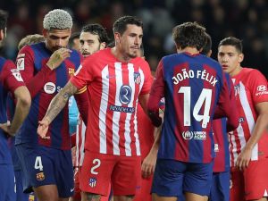 Atletico Madrid's Uruguayan defender #02 Jose Gimenez talks with Barcelona's Portuguese forward #14 Joao Felix during the Spanish league football match between FC Barcelona and Club Atletico de Madrid at the Estadi Olimpic Lluis Companys in Barcelona on December 3, 2023. (Photo by LLUIS GENE / AFP)
